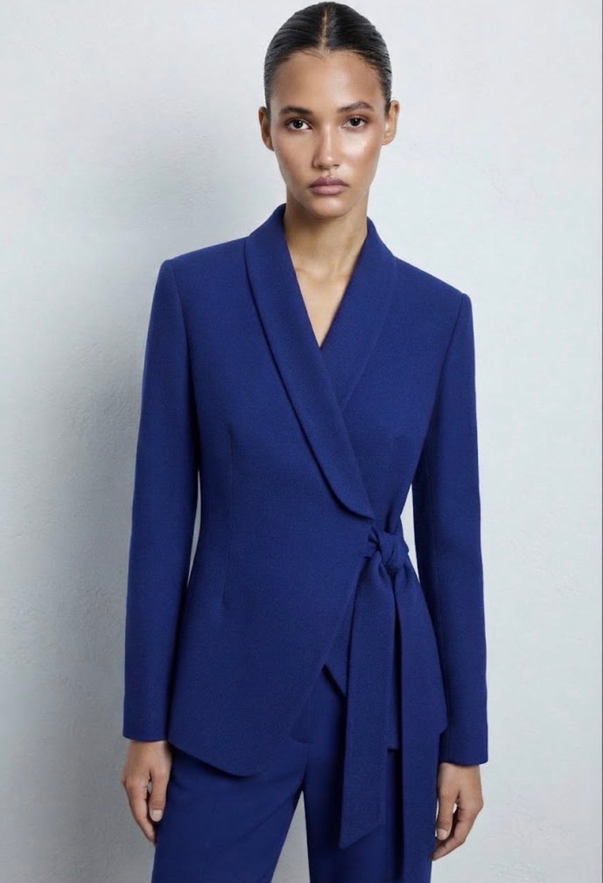 Tailleur elegante blu con blazer a portafoglio, cintura in tinta e pantaloni a palazzo