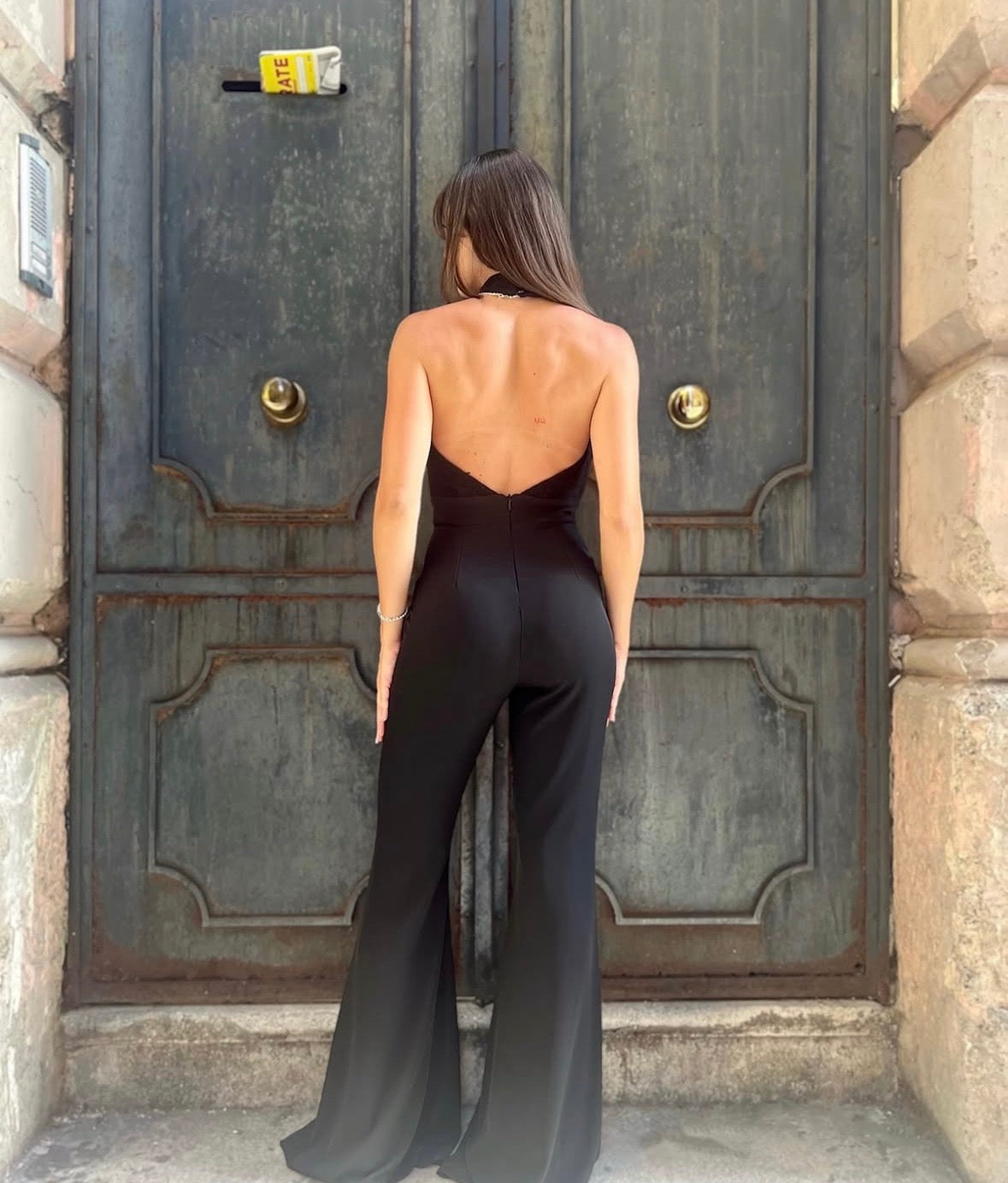 Tuta elegante nera con scollo all’americana e pantalone a zampa